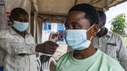 A border health officer at the Busunga crossing between Uganda and the Democratic Republic of Congo checks a traveler's temperature in Bundibugyo, on Monday.