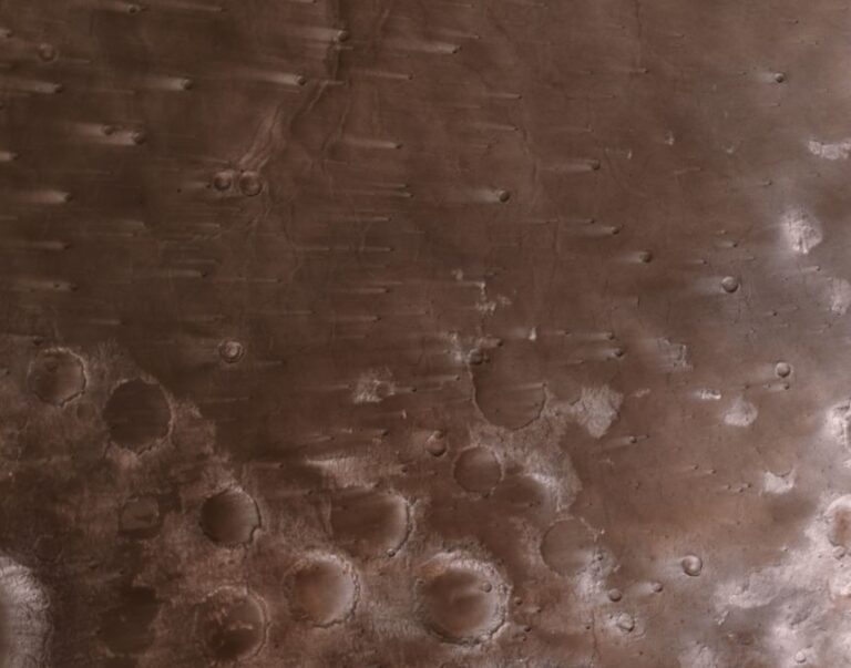 Dusty wind streaks extend about 30 miles (50 kilometers) across the Martian craters.