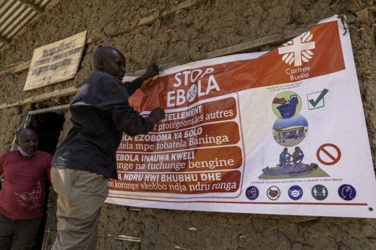 A man hangs an Ebola awareness banner in the Kigonze camp in Bunia, in the eastern Democratic Republic of the Congo, on May 28.