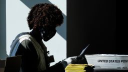 An election worker handles ballots as vote counting in the general election continues at State Farm Arena on November 4, 2020, in Atlanta.