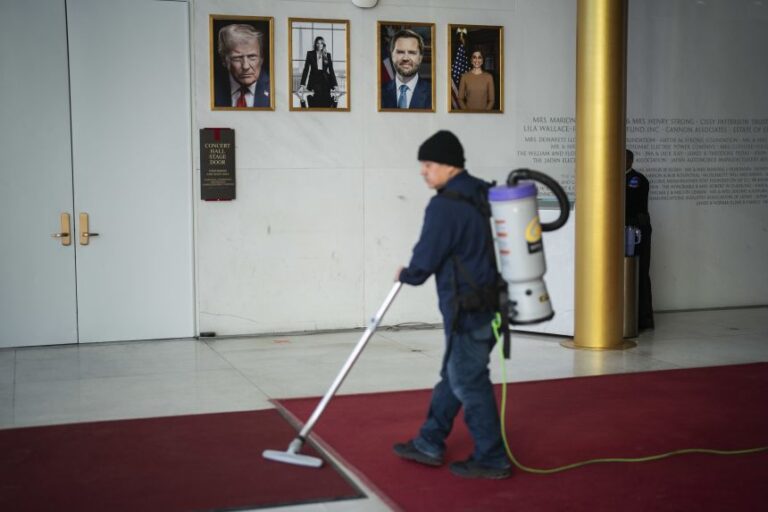 Portraits of President Donald Trump, first lady Melania Trump, Vice President JD Vance and second lady Usha Vance are seen inside the Hall of Nations as a worker vacuums at the John F. Kennedy Center for the Performing Arts on February 2, 2026, in Washington, DC.