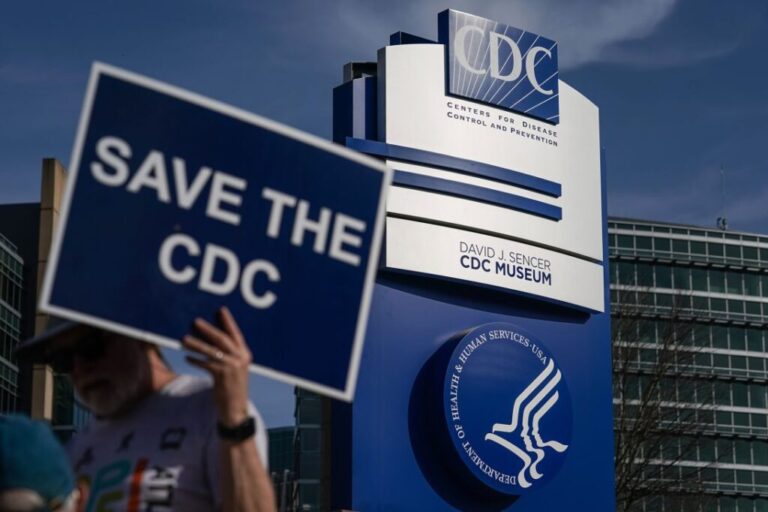 A man holds up a sign outside the main campus of the Centers For Disease Control and Prevention (CDC) in Atlanta, Georgia, on April 1, 2025.