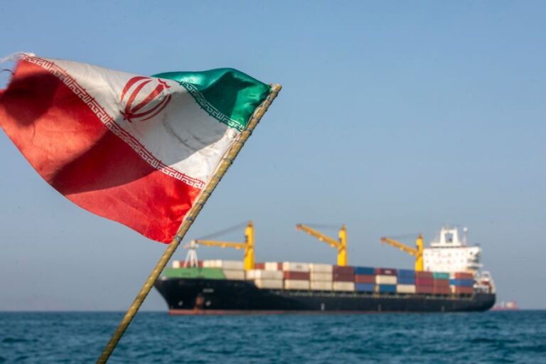 An Iranian flag flutters in the wind as ships remain anchored on May 16 in the Strait of Hormuz near Larak Island, Iran.