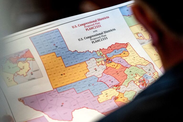State Rep. Matt Morgan holds a map of the new proposed congressional districts in Texas during a legislative session on August 20, 2025.