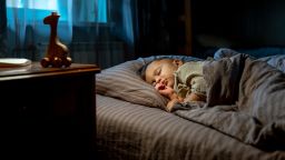 Cute baby boy sleeping on bed