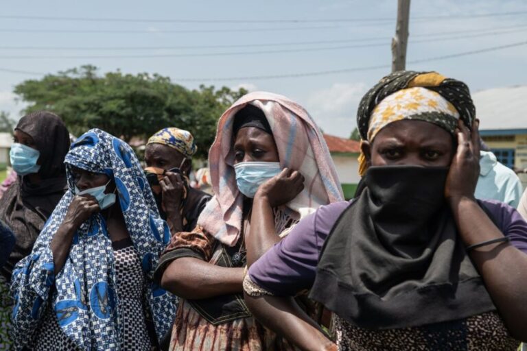 Relatives look on as the bodies of people who died of Ebola are taken from a health center in Rwampara, DRC, on Wednesday.