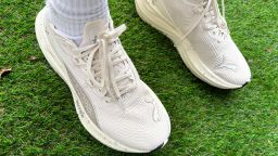 White Puma sneakers on grass.