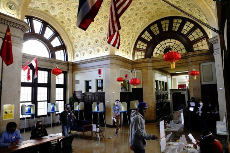 A voter receives his ballot at a polling station inside the Milwaukee Academy of Chinese Language School on Election Day in Milwaukee, Wisconsin on November 3, 2020.