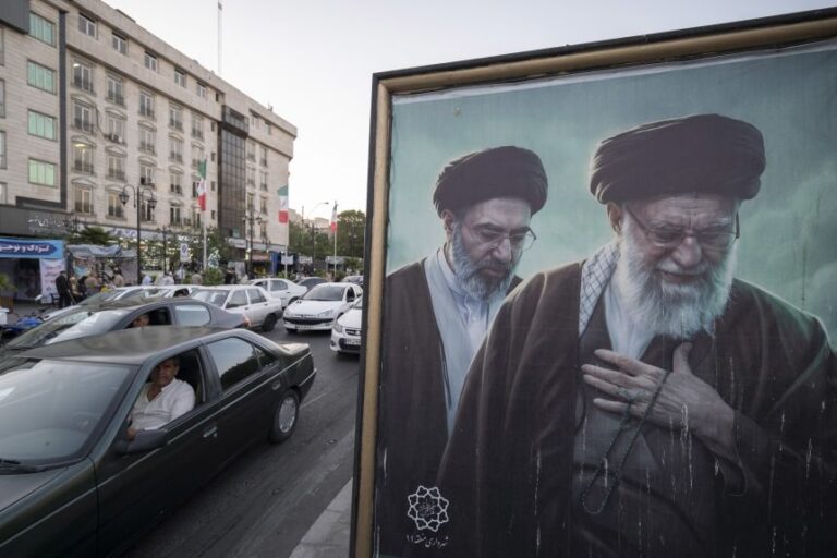 Vehicles drive past portraits of Iran's late and new supreme leaders, Ayatollah Ali Khamenei and Ayatollah Mojtaba Khamenei, in downtown Tehran on May 22.