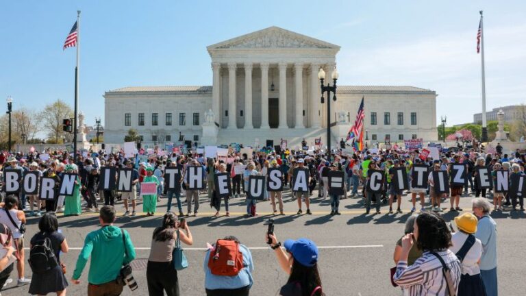 Demonstrators hold letters making up the slogan