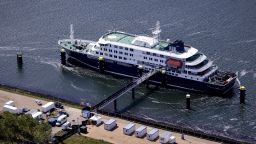 This aerial view shows the Dutch Hantavirus-hit cruise ship MV Hondius docked after arriving at the port of Rotterdam on May 18, 2026. A cruise ship that sparked global alarm after a deadly outbreak of hantavirus docked in Rotterdam harbour on May 18, with the skeleton crew facing weeks of quarantine.