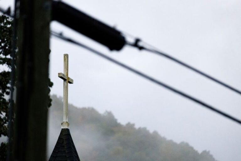 A church steeple rises in front of evening fog in Lansing, North Carolina on September 30, 2024.