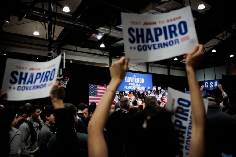 People hold signs during the Shapiro-Davis re-election campaign kickoff rally at The Alan Horwitz