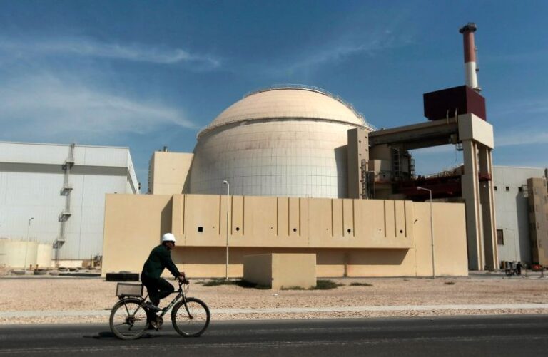 In this October 2010 photo, a worker rides a bicycle in front of the reactor building of the Bushehr nuclear power plant, just outside the southern city of Bushehr, Iran.