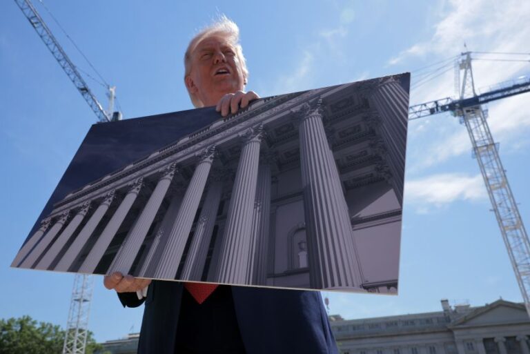 President Donald Trump holds artists renderings as he talks to reporters about his proposed White House ballroom next to the worksite on May 19, in Washington, DC.