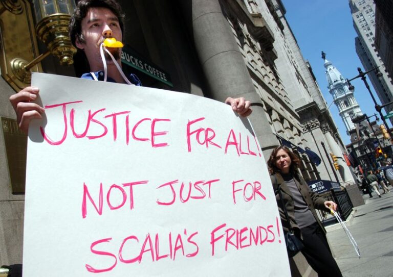 In this April 2004 photo, Gabriel Hetland holds a sign protesting against US Supreme Court Associate Justice Antonin Scalia outside a Philadelphia Bar Association luncheon in Philadelphia.