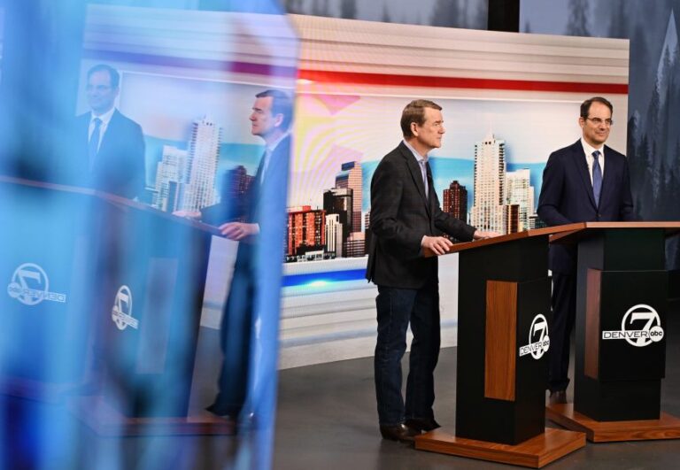 Sen. Michael Bennet, left, and Colorado Attorney General Phil Weiser attend a gubernatorial primary debate at the Denver7 studios in Denver, on May 7.