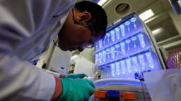 An employee works in front of centrifuge tubes containing amino acid in an automated microwave peptide synthesizer at the PeptiDream Inc. laboratory inside the The University of Tokyo in Tokyo, Japan, on Thursday, April 14, 2016. PeptiDream is part of a handful of Japanese biotech ventures that have grown into billion-dollar companies.