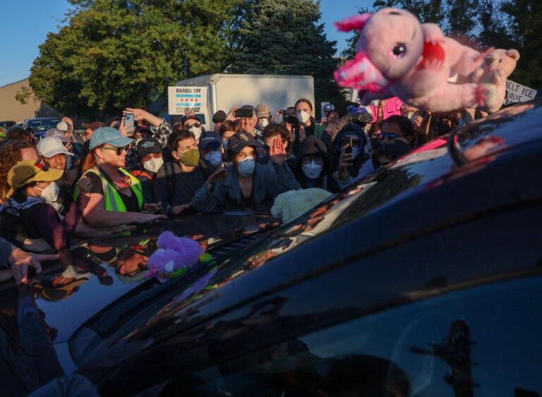 Protesters surround the SUV of a federal agent to try to prevent him from driving down Harvard Street to the US Immigration and Customs Enforcement facility in Broadview, Illinois, on Sept. 26, 2025.