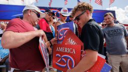 A staff member hands out signs prior to an event with US President Donald Trump, not pictured, at the Iowa State Fairgrounds in Des Moines, Iowa, US, on Thursday, July 3, 2025. Trump intends to lay out his plans to celebrate the nation's 250th anniversary, in addition to emphasizing his bid to codify tax, immigration and welfare reforms in Congress. Photographer: Scott Morgan/Bloomberg via Getty Images
