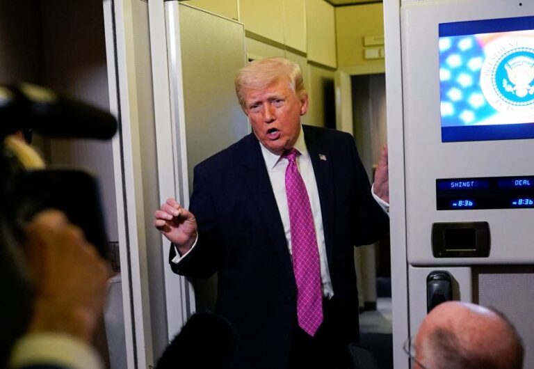 President Donald Trump talks to members of the media aboard Air Force One en route to Joint Base Andrews, Maryland, on March 29.