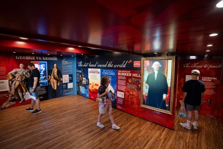 An attendee walks past an AI-powered portrait of George Washington inside the Freedom Truck, during the Great American State Fair Kickoff Celebration on June 24.