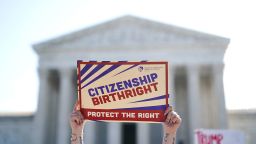 People demonstrate outside the US Supreme Court as President Donald Trump arrives to attend oral arguments on April 1, 2026 in Washington, DC.