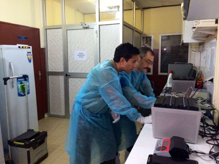 Dr. Sanjay Gupta works in WHO's mobile lab next door to MSF's Ebola isolation treatment area in Conakry, Guinea.