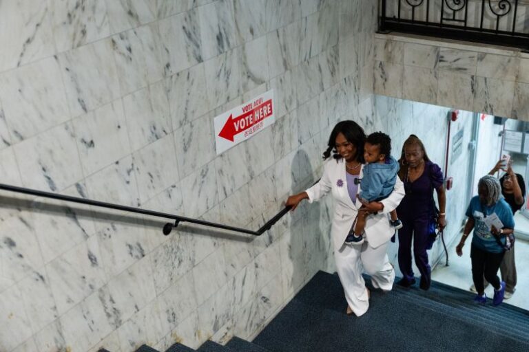 Janeese Lewis George, candidate for DC mayor, carries her son, Pierce, as she arrives at Prince Hall Masonic Temple, a polling location, to vote in Washington, DC, on Monday, June 8.