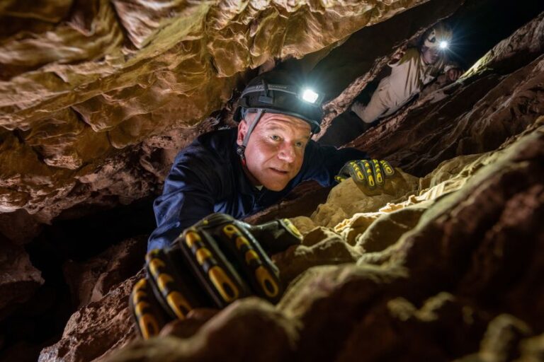 Paleoanthropologist Lee Berger makes the awkward climb on the main thoroughfare through Rising Star Cave. The labyrinthine system stretches for more than 2.5 miles (4 kilometers) and has a vertical depth of 328 feet (100 meters).
