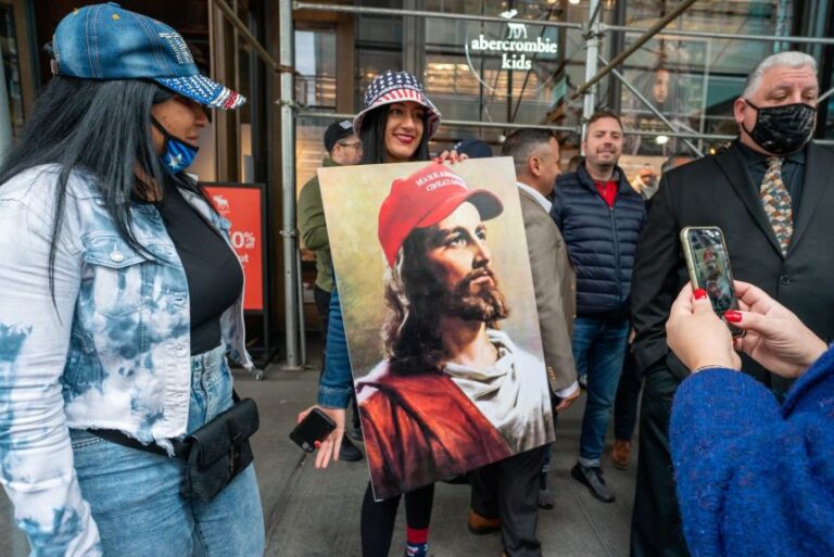 A person holds a painting of Jesus wearing a