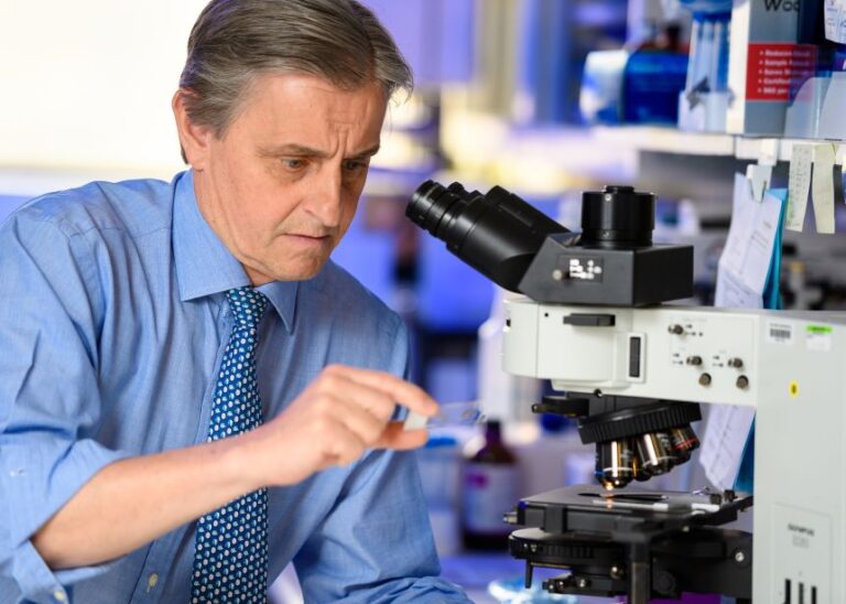 Tracey studies microscopic slides in the lab as part of ongoing research on the vagus nerve.