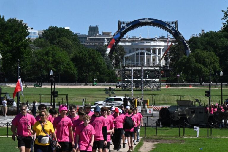 Visitors walk near the White House as cranes work on the construction on the South Lawn of the White House on May 29.