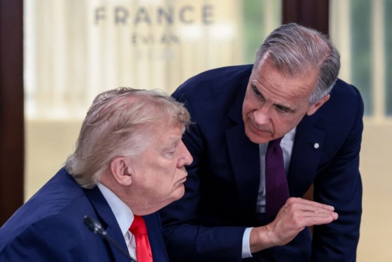 US President Donald Trump (L) speaks with Canada's Prime Minister Mark Carney during a work lunch as part of the G7 summit, in Evian, eastern France, on Tuesday.