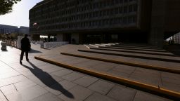 A man casts a shadow as he walks toward the Hubert H. Humphrey Building, headquarters of the Department of Health and Human Services (HHS), after it was reported that the U.S. President Donald Trump administration fired staff at the Centers for Disease Control and Prevention and at the Food and Drug Administration, as it embarked on its plan to cut 10,000 jobs at HHS, in Washington, D.C., U.S., April 1, 2025.