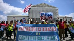 People hold a banner as they participate in a protest outside the US Supreme Court over President Donald Trump's move to end birthright citizenship on May 15, 2025.