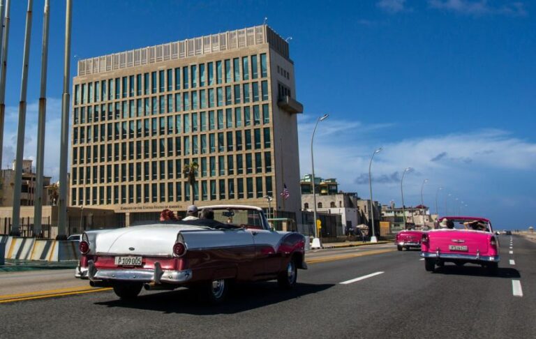 In this 2017 photo, tourists ride classic convertible cars on the Malecon beside the United States Embassy in Havana, Cuba.