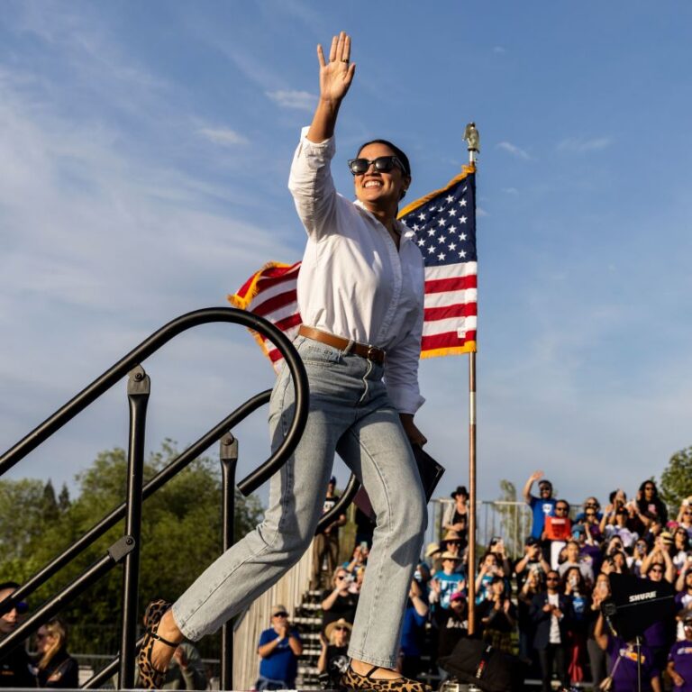 US Rep. Alexandria Ocasio-Cortez of New York waves to the crowd during a stop of the 'Fighting Oligarchy' rally at Folsom lake College in Folsom, California, on April 15, 2025.