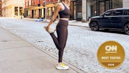 A woman stretching while wearing running tights before a jog.