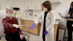 Keith Krehbiel holds his hand out for Dr. Helen Bronte-Stewart. After he had the adaptive deep brain stimulation (aDBS) device implanted, he said his hand tremor went away “almost immediately.”