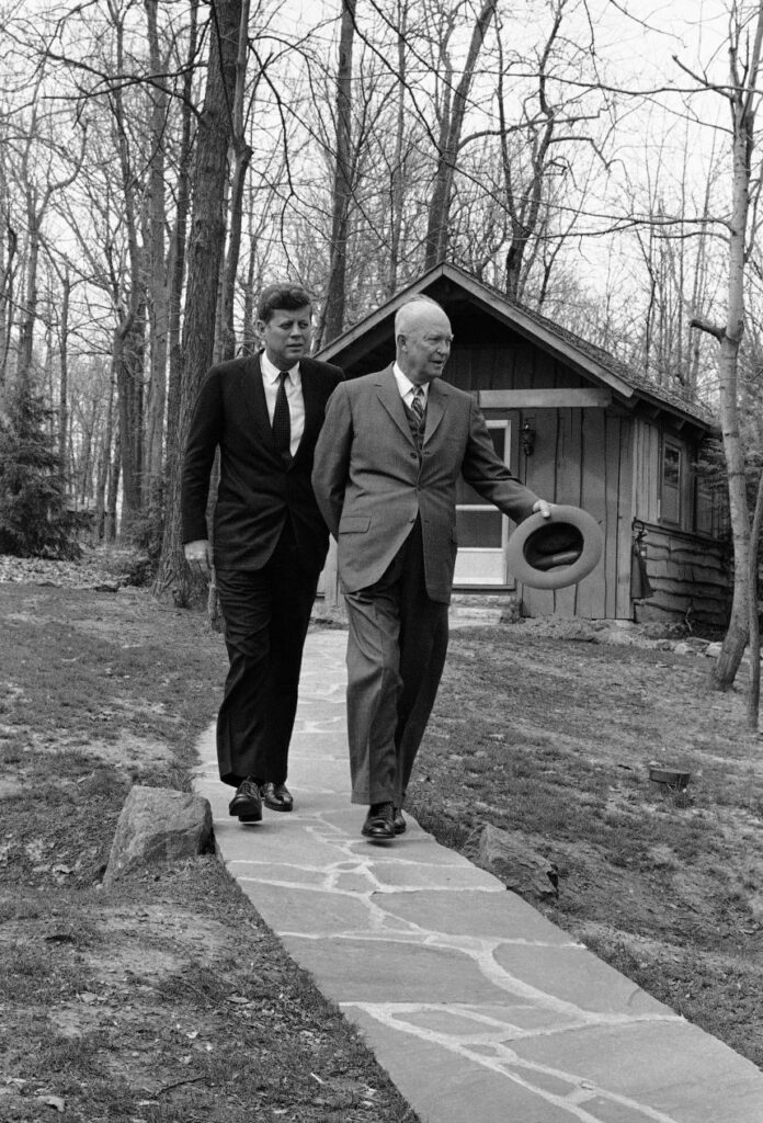 President John Kennedy and former President Dwight Eisenhower walk at Camp David on April 22, 1961, after flying there to discuss the Cuban crisis.