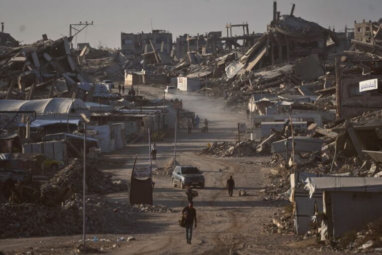 Palestinians walk along a road surrounded by buildings destroyed in Israeli military strikes during the Israel-Hamas war, in Jabaliya, Gaza Strip, on July 2, 2026.