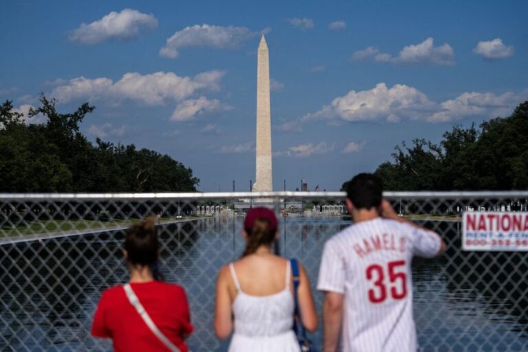 Visitors look through fencing at the Reflecting Pool near the Lincoln Memorial on the National Mall, June 25.
