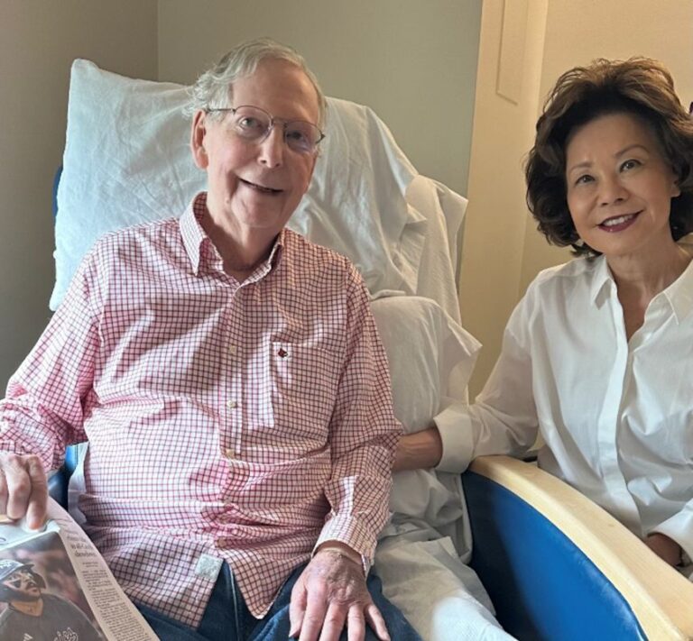 In this photo released on Sunday by Sen. Mitch McConnell's office, he is seen in the hospital with his wife and a current newspaper.