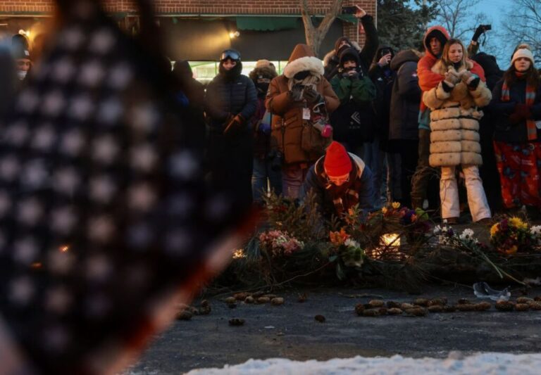 People gather around a makeshift memorial at the site where Pretti died in Minneapolis on January 24.