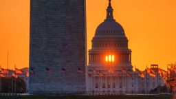 WASHINGTON, DC - MARCH 23: The rising sun flares through the windows of the U.S. Capitol Dome as it illuminates the U.S. Flags circling the base of the Washington Monument on March 23, 2025, in Washington, DC. (Photo by J. David Ake/Getty Images)