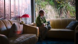 Pensive Caucasian man sitting on sofa near window