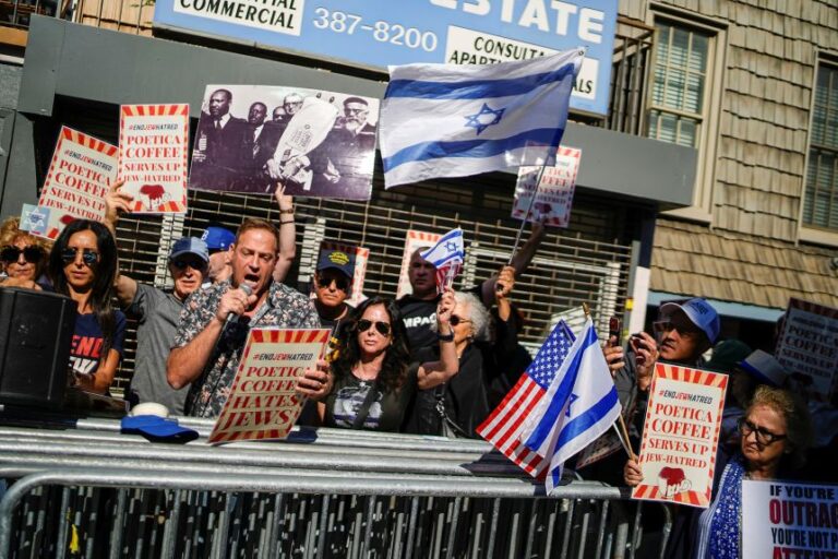 Protesters hold placards and Israeli flags as they gather during an '#EndJewHatred' rally outside a coffee shop in the Brooklyn borough of New York, on June 24, following a social media post by the shop banning Jewish Rep. Dan Goldman over his views on Israel.