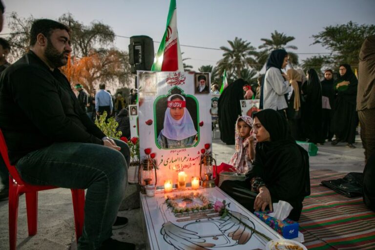 MINAB, IRAN - MAY 14: Relatives sit by the grave of a deceased relative, as people gather to mourn at the cemetery of Minab City on May 14, 2026 in Minab, Iran. On 28 February this year, a US military launched a missile strike that destroyed the all-girls Al-Shajara School in Minab, Iran.(Photo by Majid Saeedi/Getty Images)
