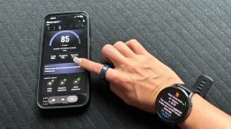 A woman scrolls her Eight Sleep app while wearing a Garmin Venu 4 and Oura Ring 4 Ceramic.
